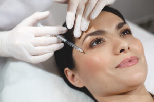 Beautiful dark-haired woman smiles during a liquid facelift